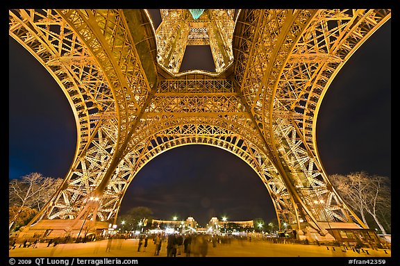 Eiffel Tower pilars from below and Ecole Militaire at night. Paris, France