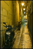 Motorcycles parked in narrow alley at night. Quartier Latin, Paris, France