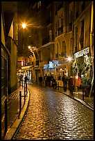 Cobblestone street with restaurants by night. Quartier Latin, Paris, France (color)