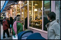 Customers wait in line in front of a popular bakery. Paris, France ( color)