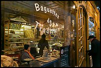 Elderly man entering bakery with people inside. Paris, France