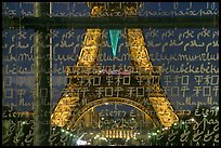 Lit Eiffel Tower seen through the words Peace written in many languages. Paris, France ( color)