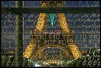 Lit Eiffel Tower seen through the words Peace written in many languages. Paris, France (color)