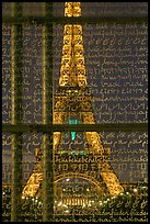 Illuminated Eiffel Tower seen through peace memorial. Paris, France