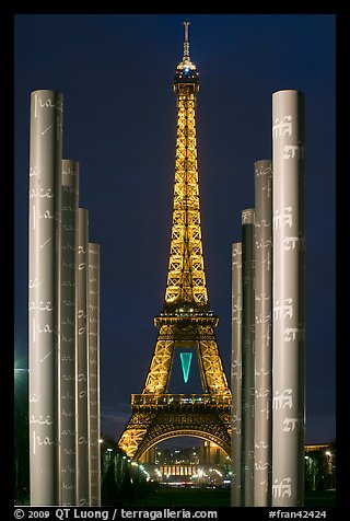 Columns of memorial to peace end Eiffel Tower by night. Paris, France