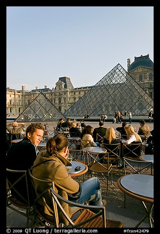 Couple sitting on terrace in Louvre main courtyard. Paris, France (color)