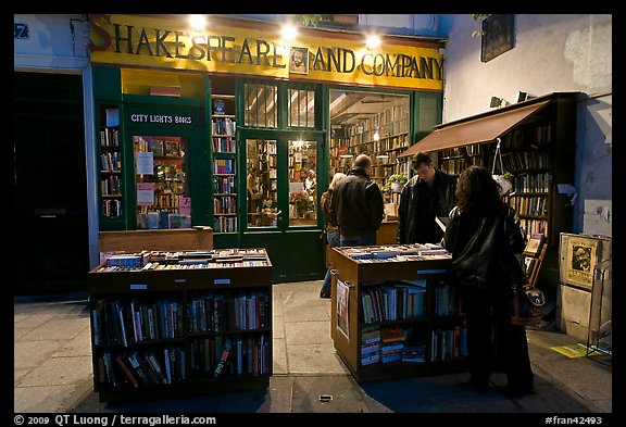 People reading in front of bookstore at night. Quartier Latin, Paris, France