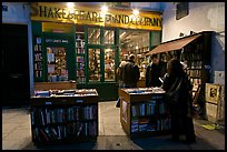 People reading in front of bookstore at night. Quartier Latin, Paris, France