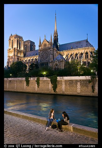 Two women having picnic across Notre Dame cathedral. Paris, France (color)