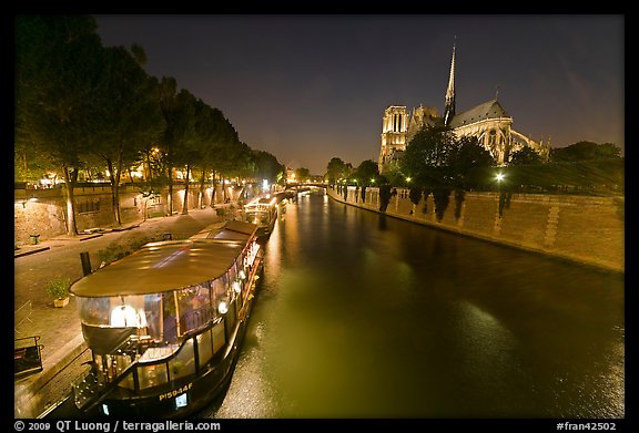 Quay, lighted boats, Seine River and Notre Dame at night. Paris, France (color)