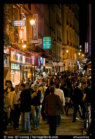 Busy pedestrian street at night. Quartier Latin, Paris, France