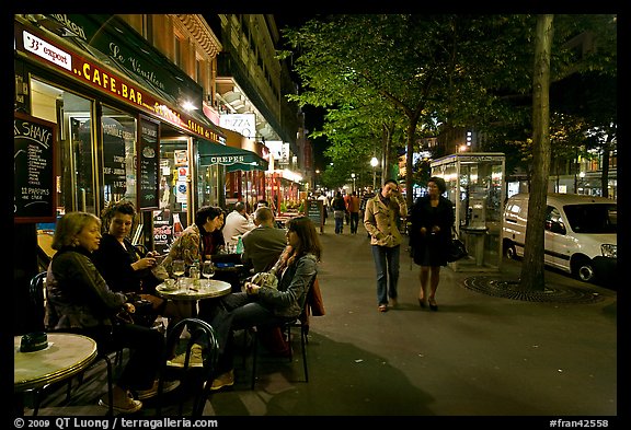 Cafe bar on sidewalk of a Grand Boulevard at night. Paris, France (color)