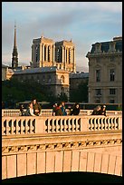 Watching the sunset from a bridge, with Notre Dame towers behind. Paris, France (color)