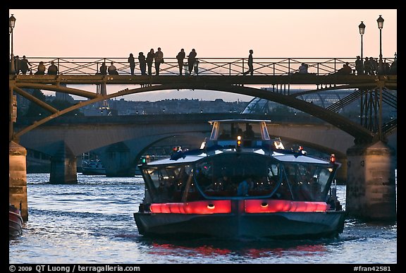 Tour boat below Pont des Arts at sunset. Paris, France