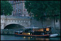 Lighted live-in barge, quay, and Pont-Neuf. Paris, France (color)