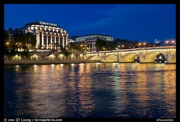 Pont Neuf and Samaritaine reflected in Seine River at night. Paris, France