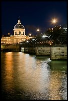 Institut de France and Pont des Arts reflected in Seine river at night. Paris, France