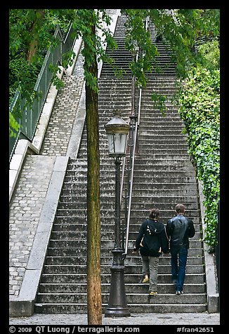 Couple walking up steet stairs, Montmartre. Paris, France