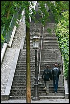 Couple walking up steet stairs, Montmartre. Paris, France