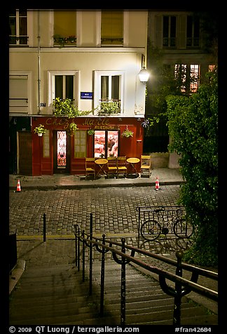 Hillside stairs on butte, street and restaurant at night, Montmartre. Paris, France