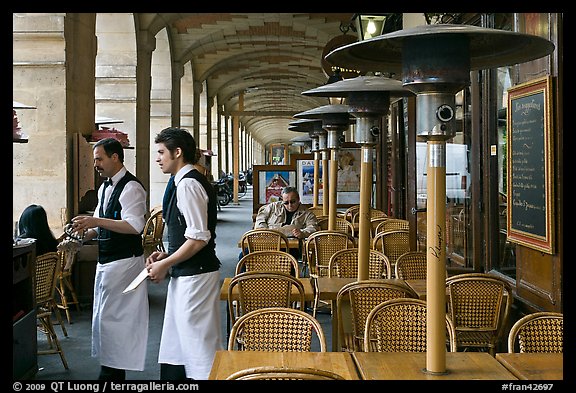 Waiters and cafe in place Victor Hugo arcades. Paris, France