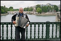 Street musician playing accordeon on River Seine bridge. Paris, France ( color)