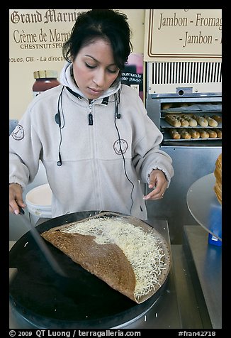 Woman preparing a crepe with cheese. Paris, France (color)