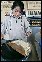 Woman preparing a crepe with cheese. Paris, France