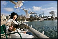 Elderly woman and seagulls, Tuileries garden. Paris, France