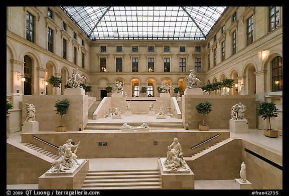 Louvre Museum room with sculptures and skylight. Paris, France