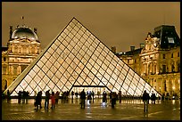 People standing in front of Louvre Pyramid by night. Paris, France ( color)
