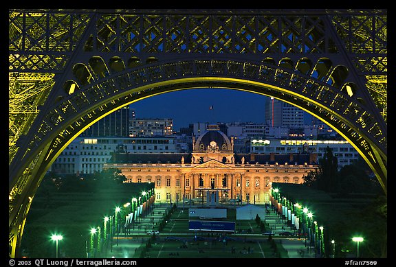 Ecole Militaire (Military Academy) seen through Eiffel Tower at night. Paris, France