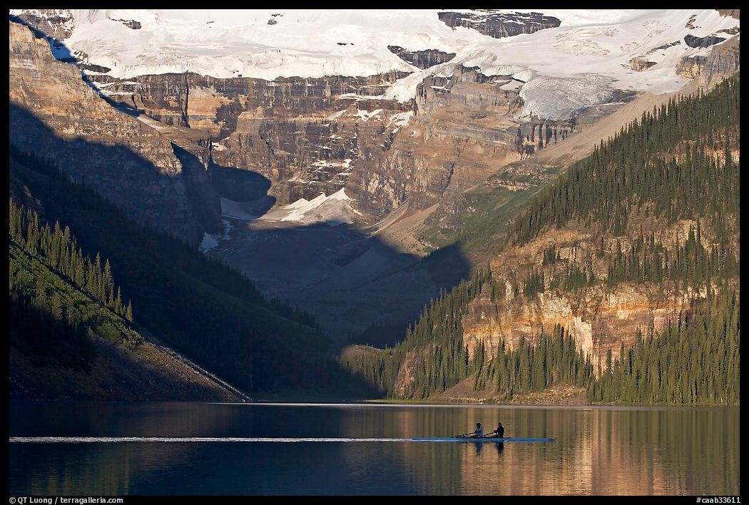 Rowers on Lake Louise, below Victoria Glacier, early morning. Banff National Park, Canadian Rockies, Alberta, Canada