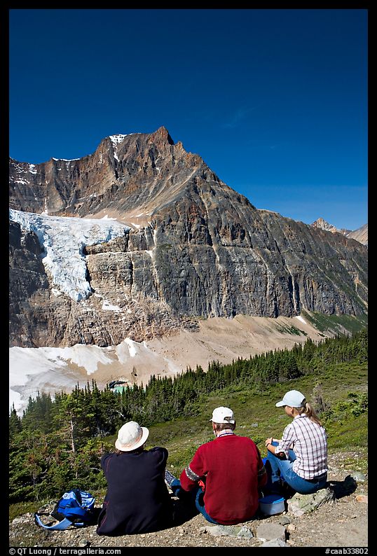 Hikers sitting in front of Mt Edith Cavell next to trail. Jasper National Park, Canadian Rockies, Alberta, Canada