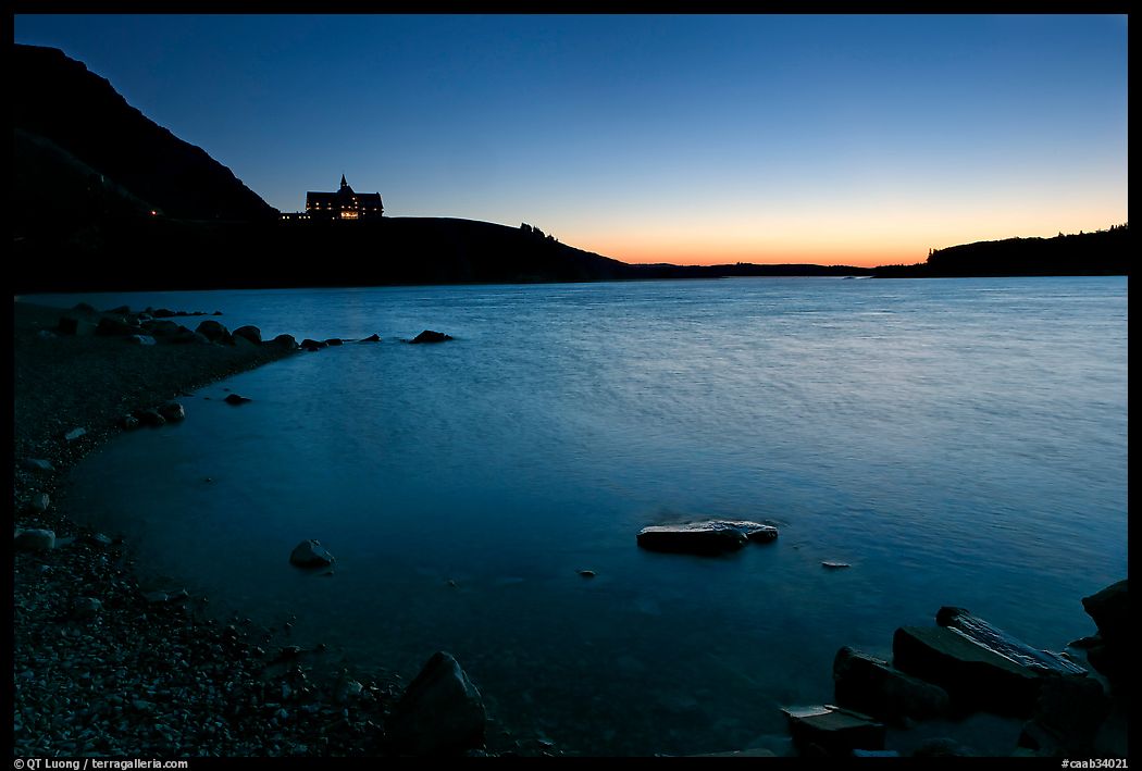 Boulders in Waterton Lake and Prince of Wales hotel, dawn. Waterton Lakes National Park, Alberta, Canada