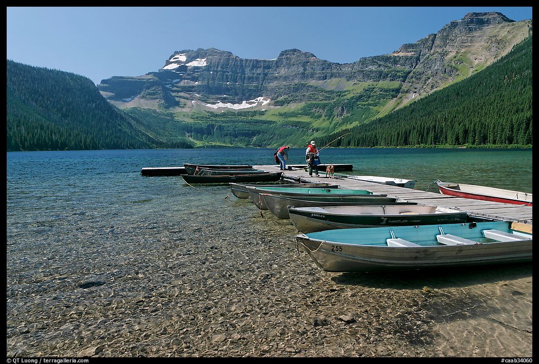 Fishermen walking on dock after unloading a canoe, Cameron Lake. Waterton Lakes National Park, Alberta, Canada