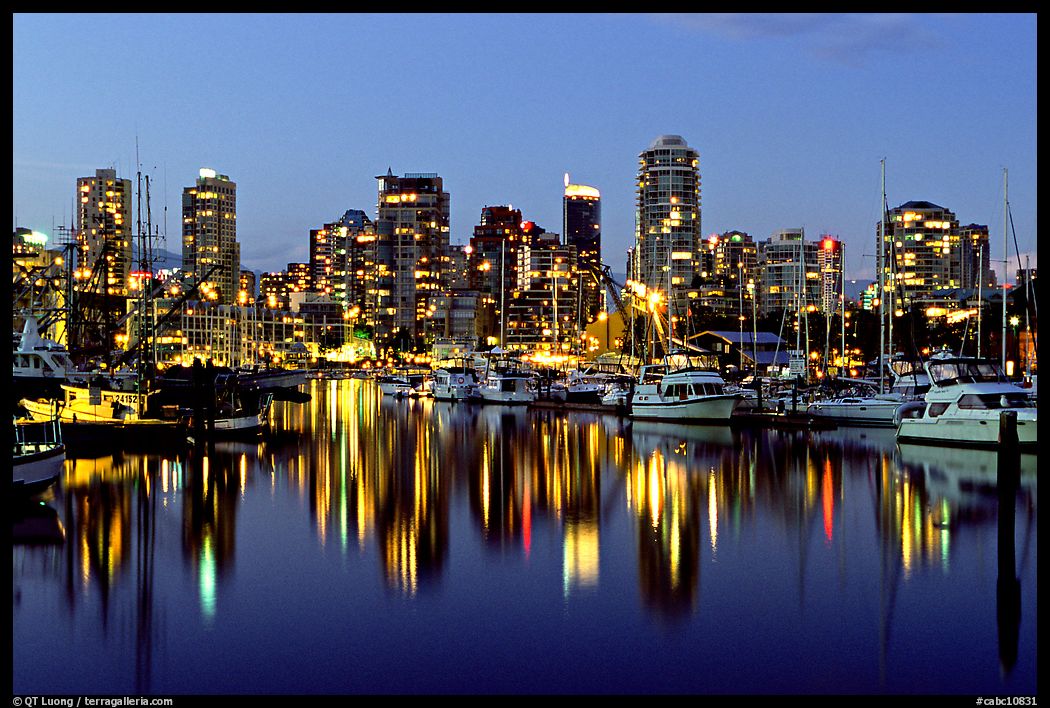 Fishing boats and skyline light reflected at night. Vancouver, British Columbia, Canada