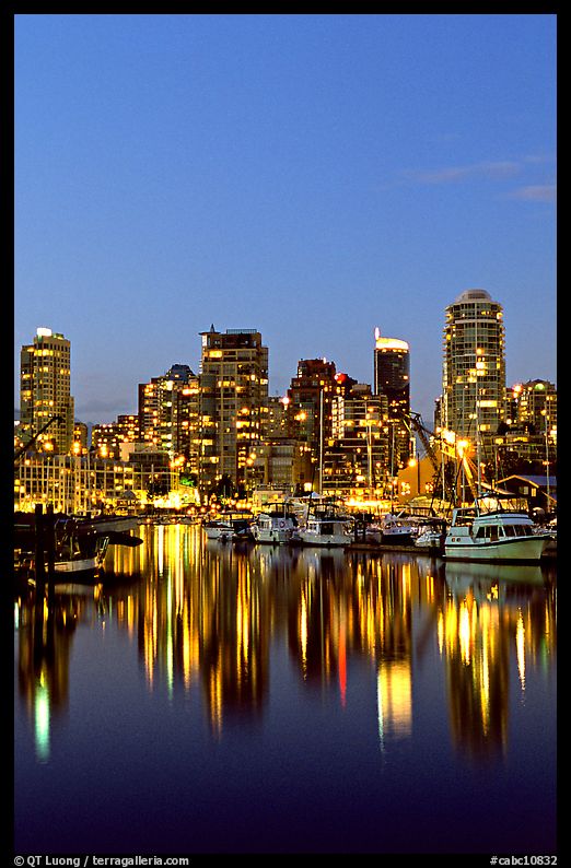 Fishing boats and skyline light reflected at night. Vancouver, British Columbia, Canada