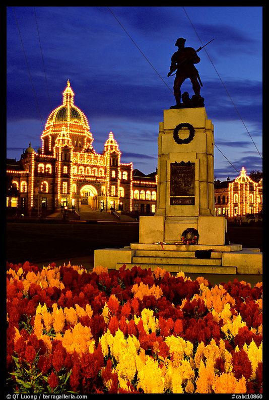 Flowers, memorial statue and illuminated parliament building at night. Victoria, British Columbia, Canada