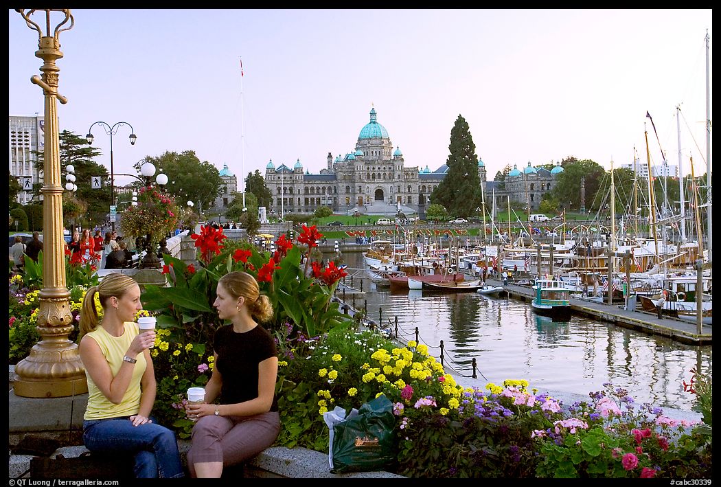 Women drinking coffee at the Inner Harbour, sunset. Victoria, British Columbia, Canada