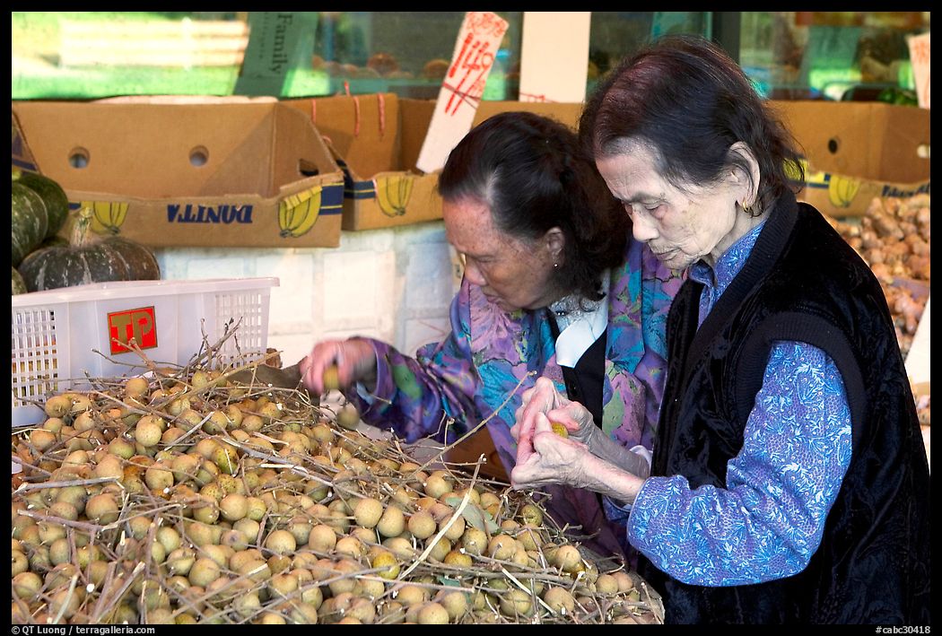 Two elderly women choosing tropical fruit. Vancouver, British Columbia, Canada