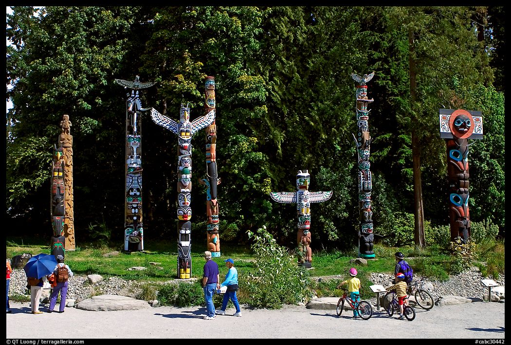 Visitors loooking at Totems, Stanley Park. Vancouver, British Columbia, Canada