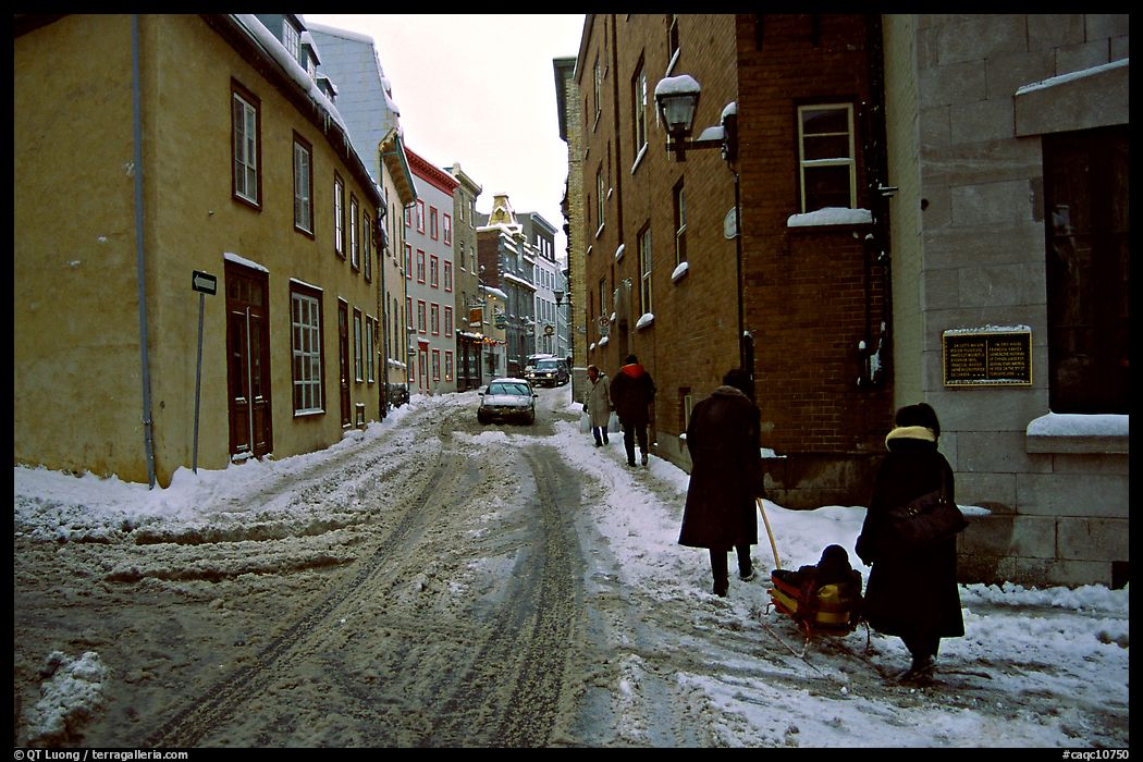 Residents pulling a sled with a child in a street, Quebec City. Quebec, Canada