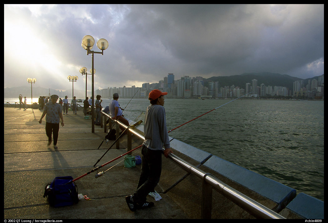 Fishing on the waterfront promenade, sunrise. Hong-Kong, China