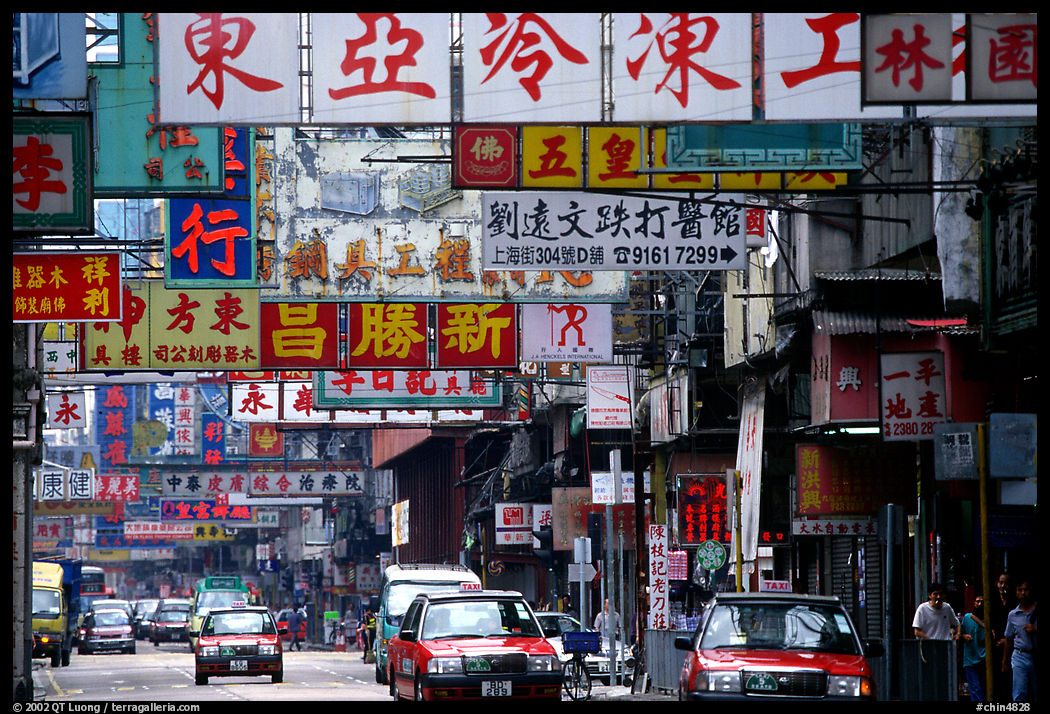 Taxicabs in a street filled up with signs in Chinese, Kowloon. Hong-Kong, China