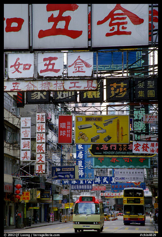 Busses in a street filled up with signs in Chinese, Kowloon. Hong-Kong, China