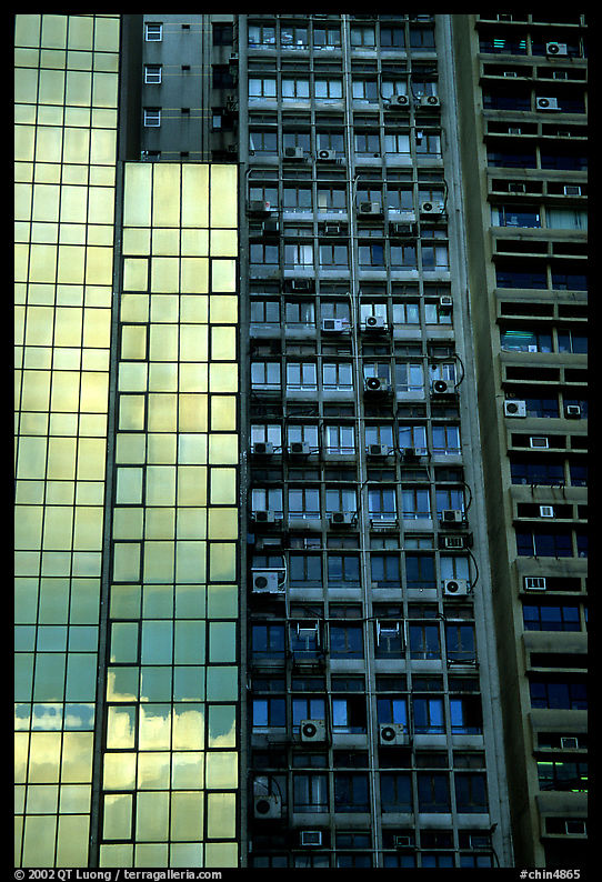Glass building next to older buildings with air conditioners, Hong-Kong Island. Hong-Kong, China