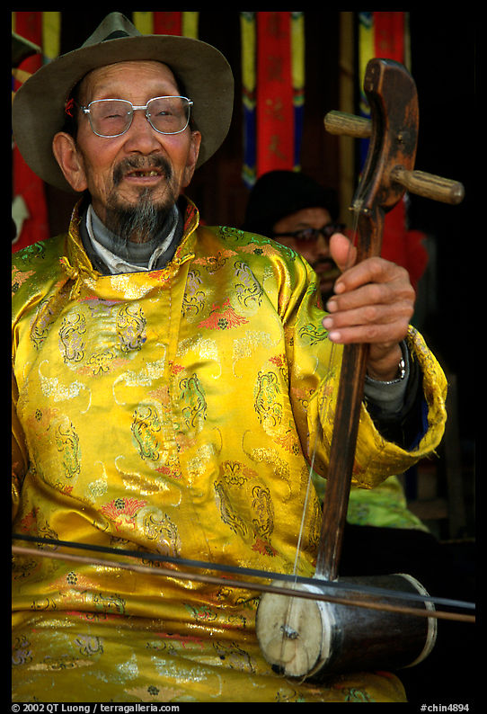 Elderly musician playing the traditional two-stringed Ehru. Baisha, Yunnan, China