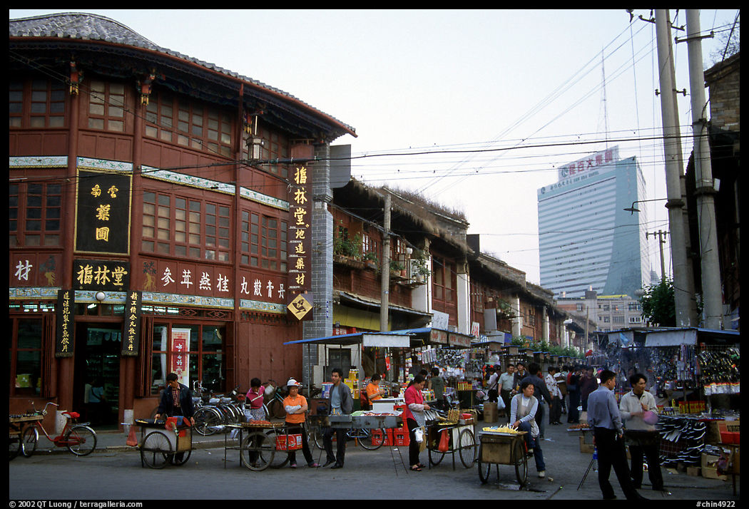 Old wooden buildings, with a high rise in the background. Kunming, Yunnan, China