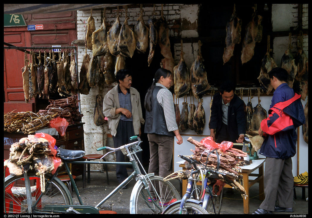 Loading roasted meat on a bicycle. Kunming, Yunnan, China